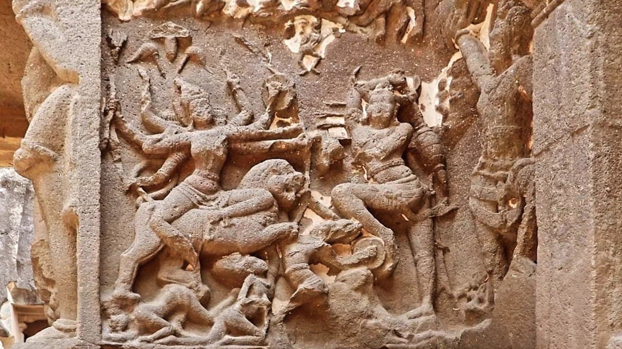 A rock-cut relief of Mahishasuramardini, the goddess riding a lion into the buffalo demon's army