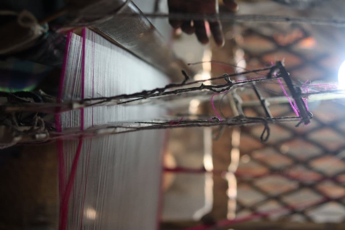 Jamdani weaving at Narayanganj: two weavers at one loom, inserting each motif by hand with pointed bamboo sticks.