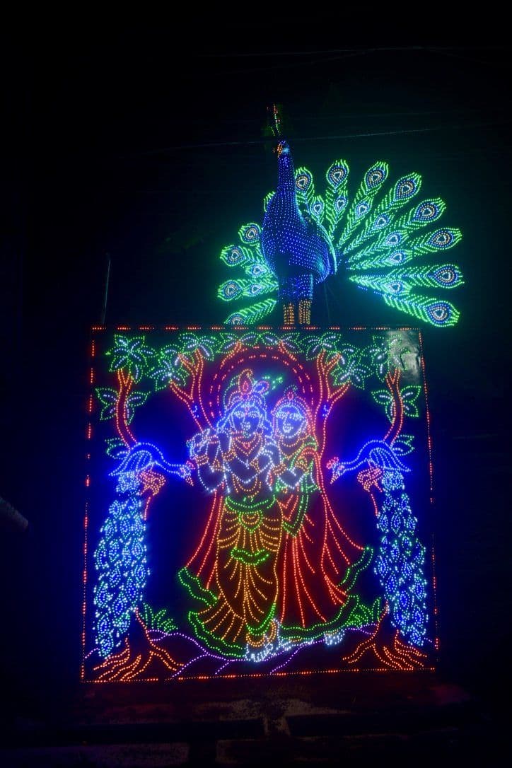 A lit corridor in Chandannagar: the panels are designed to be walked under, making the street between pandals part of the work.