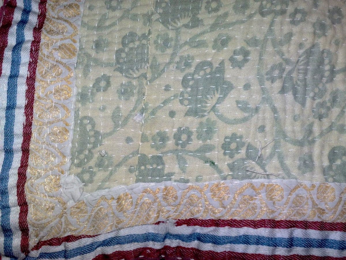Kantha at close range: rows of plain running stitch through several layers, which is what makes the surface ripple.